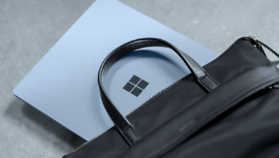 A Surface device partially hidden inside a leather laptop bag.