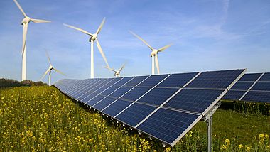 Solar Panels und Windräder auf einem grünen Feld.